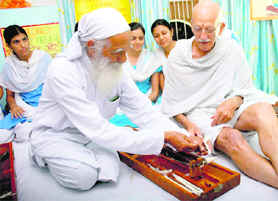 Joined by a common thread: Renowned environmentalist Sunderlal Bahuguna teaches Mahatma Gandhi’s lookalike Bernie Meyer how to operate a spinning wheel at a function held at Dev Samaj College in Chandigarh on Wednesday.