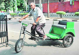 A rickshaw-puller test rides a battery-operated rickshaw at the MC office in Chandigarh on Wednesday.