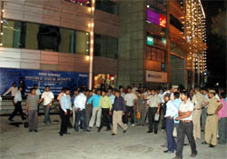 Policemen and customers stand in front of Sahara Mall during a mock drill in Gurgaon on Wednesday evening.