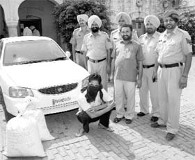 An accused in police custody with sacks of poppy husk at Rajpura on Thursday.