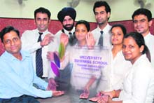 Student of UBS, Panjab University, along with their chairperson Dinesh Gupta, hold the memento of honour. 