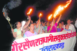 Workers of the Rajdhani Sanyukt Sangharsh Morcha hold a torchlight procession in Dehradun 