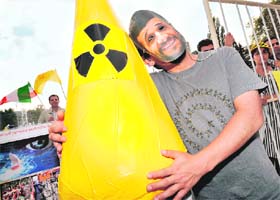 A man wearing a mask of Iranian President Mahmoud Ahmadinejad poses close to a fake nuclear rocket during a protest in Geneva