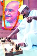 A Gandhi follower spins a charkha on Gandjhi Jayanti in Amritsar on Friday.