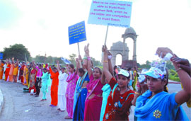 Women form a human chain during the launch of National Campaign on Prevention of Violence against Women on the occasion of 140th birth anniversary of Mahatma Gandhi, at India Gate in New Delhi on Friday.