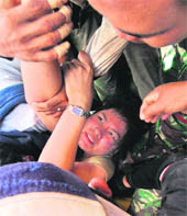 An Indonesian woman is rescued from the rubble of a building in the Sumatran city of Padang on Friday. A 7.6- magnitude earthquake toppled buildings in the area on September 30