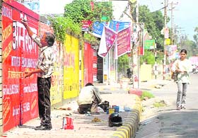 A painter paints an advertisement on a wall in Dehradun