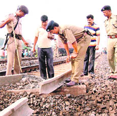 Policemen examine a damaged portion of the railway line in Purulia district of West Bengal on Saturday.