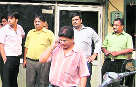 People outside a shop where robbery took place in Ludhiana on Saturday.