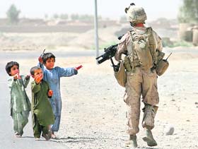 Children approach a US Marine during a foot patrol in the centre of Garmsir district in Helmand province, Afghanistan, on Sunday.