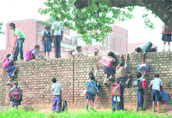 Students of Goverment School, Sector 25, Chandigarh, climb the school wall to reach their homes in an adjoining locality.