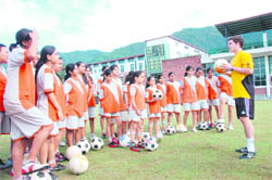 Gary Judge, football coach of Inspire Academy, UK, gives tips to girls at Unison School, Dehradun, on Monday.