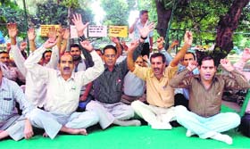 Members of the J&K Housing Board Employees Association protest at Gandhi Nagar in Jammu