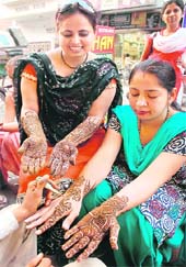 Women get mehndi applied to their hands before Karva Chauth in Bathinda on Monday