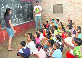 Students from various city colleges teach slum children at AIE Centre in Colony No. 4