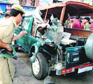 Security personnel inspect the damaged vehicle at the Lal Chowk in Srinagar on Tuesday.