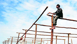 Labourers erect a temporary shelter for flood victims in Raichur, Karnataka.