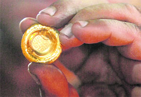 A goldsmith displays a gold nugget after creating it in his workshop in Karachi on Wednesday. Gold struck an all-time high on Wednesday for the second time in as many days as the dollar weakened further, taking copper and crude oil up.