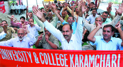 Delhi University staff shout slogans during a demonstration at the UGC Office in New Delhi to press for their demands