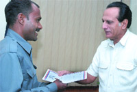 Delhi police commissioner Y.S. Dadwal presents an award to Vijay Kumar, an autorickshaw driver who helped rescue a child from kidnappers, in New Delhi