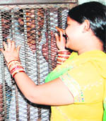 A woman meets her husband, who is lodged in the Central Jail, Amritsar, on Karva Chauth on Wednesday.