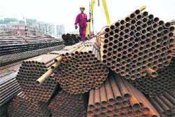 A worker walks on seamless steel pipes at a steel market in Hefei, Anhui province, on Thursday. China is "dissatisfied" with a European Unions decision to impose anti-dumping tariffs on seamless steel pipes from China, and believes the move ignores global trade rules, the official Xinhua news agency reported