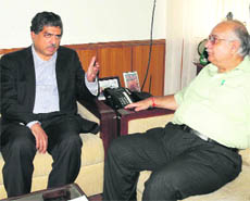 Nandan Nilekani, chief of the Unique Identification Authority of India, talks to Uttarakhand Chief Secretary Indu Kumar Pande in Dehradun on Thursday.
