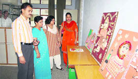 Judges have a look at Sanjhi paintaings during a competition in Fatehabad.