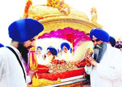 Guru Granth Sahib kept in a golden palanquin in the Parkarma of the Golden Temple during a procession held on the eve of the birth anniversary of Guru Ram Dass 