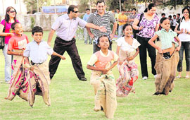 Children from Bapu Dham Colony participate in a sack race organised by Dell in Chandigarh on Friday.