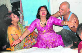 An inconsolable Anchal Sharma, widow of Rajnish Sharma, along with other family members wails at their house in Jammu on Friday.