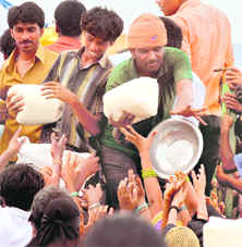 Flood victims gather in front of a vehicle distributing rice in an AP village on Friday.