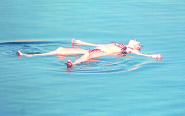 The Dead Sea is comfortably warm. Visitors float effortlessly on its buoyant waters
