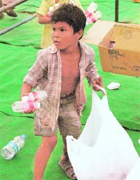 HIS FATE REMAINS THE SAME: A boy collects plastic bottles after an SAD rally in Ambala City