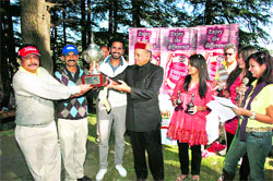 Chief Minister PK Dhumal gives away prizes to winners of the Dr YS Parmar Memorial Golf Tournament at Naldehra near Shimla on Sunday.