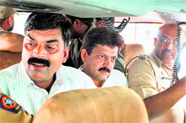 Cops take away Shiv Sena candidate Ajay Bhosale (C) after he was attacked in Pune.