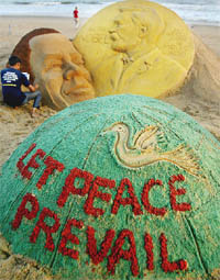 Sand artist Sudersan Patnaik gives final touches to a sculpture of US President Barack Obama at Golden Sea Beach in Puri, Orissa