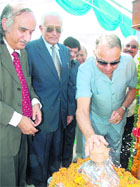 Administrator SF Rodrigues breaks a coconut on the stone- laying ceremony of Education City on Monday.