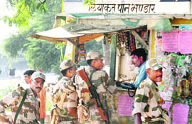 Paramilitary personnel at a paan shop on the eve of assembly elections in Gurgaon on Monday.