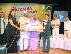 Governor Jagannath Pahadia honours a hockey player in Panipat.