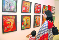 A woman visitor has a close look at paintings on display at an art exhibition Beyond the Horizon in Gurgaon. 