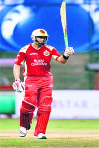 Bangalore Royal Challengers batsman Jaques Kallis raises his bat after completing his half century against Otago Volts in Chinnaswamy Stadium in Bangalore