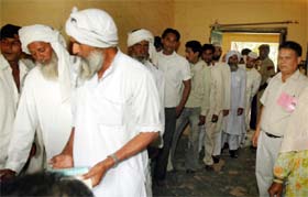 An elderly voter is escorted to a polling booth in the Bhim Nagar locality of Gurgaon