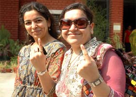 Two girls come out of a booth after casting their votes in Gurgaon