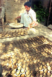 A potter makes earthen lamps at a workshop in Jammu.