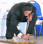 Brazilian AC Milans football player Ronaldinho signs his foot print on Tuesday in Monaco after he won the 2009 Golden Foot Award.
