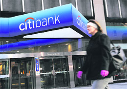 In this file photo, a woman walks past a Citibank branch at its world headquarters in New York. Struggling banking giant Citigroup topped expectations on Thursday by posting a Q3 profit of $101 million