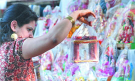 A woman selects idols of Ganesh and Lakshmi.