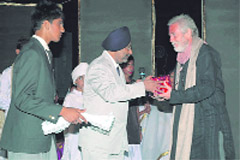 Actor Tom Alter receives a memento at the Founders Day function of  Kasiga School in Dehradun on Friday.