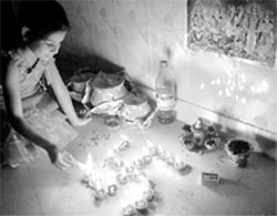 A girl lights diyas on Diwali in Dera Bassi.